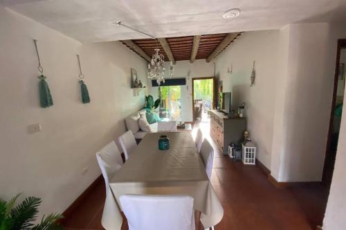 uma sala de jantar com uma mesa e cadeiras brancas em Almarena, tu casa en Punta del Este em Manantiales
