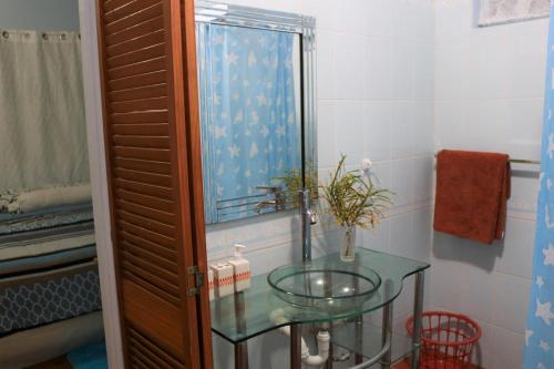 a bathroom with a glass sink and a mirror at Ocean Views and Hospitable Hosts in Castries