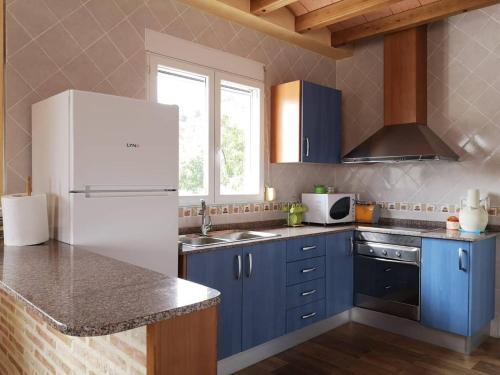 a kitchen with blue cabinets and a white refrigerator at Finca La Ecarada. Férez (Albacete) in Férez