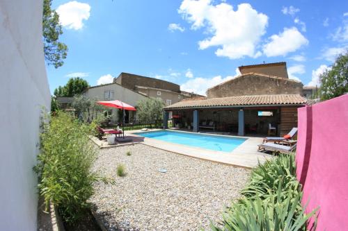 une cour arrière avec une piscine et une maison dans l'établissement Chambres d'hôtes La Pierrerie, à Laure-Minervois