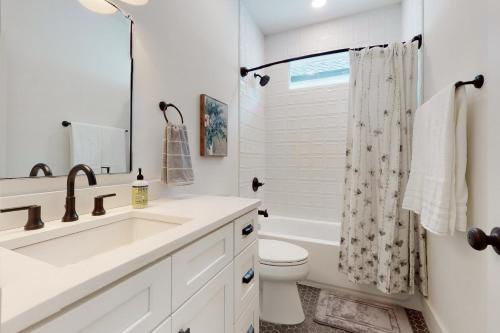 a white bathroom with a sink and a toilet at The Cottonwood in Clayton