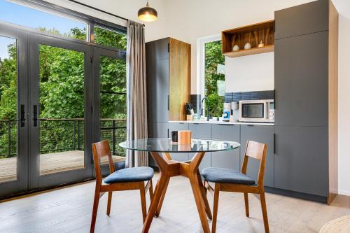 a kitchen and dining room with a glass table and chairs at The Treehouse in Seattle