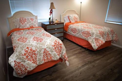 - une chambre avec deux lits et une commode avec une lampe dans l'établissement Spacious Home, Close to Attractions, Sleeps 4, à Orlando