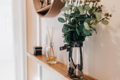 a vase filled with flowers sitting on a shelf at Oakgrove Apartment - 2 Bedroom with Terrance and private parking in Milton Keynes