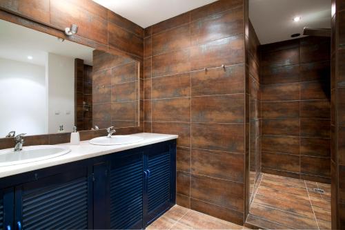 baño con 2 lavabos y paredes de madera en Lost Lisbon :: Cais House, en Lisboa
