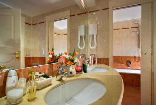 a bathroom with two sinks and a large mirror at Hotel Bristol Buja in Abano Terme