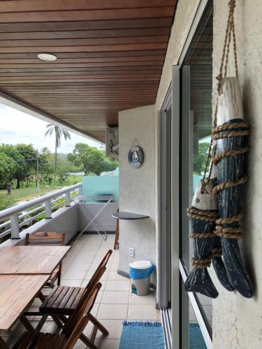 a balcony with a table and chairs and a wooden ceiling at Blue Marlin Cotovelo - Vista Vale - Reformado in Parnamirim