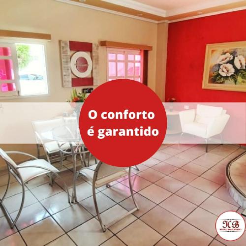 a room with a red wall and a table and chairs at Hotel Boulevard in Araripina