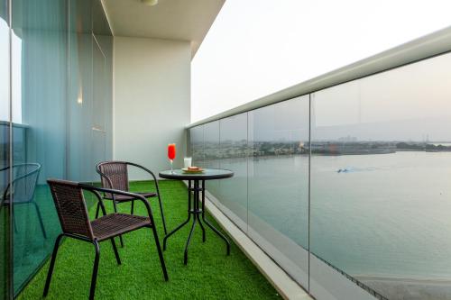 a balcony with a table and chairs and a view of the water at Live feel and get lost in waters in Ras al Khaimah