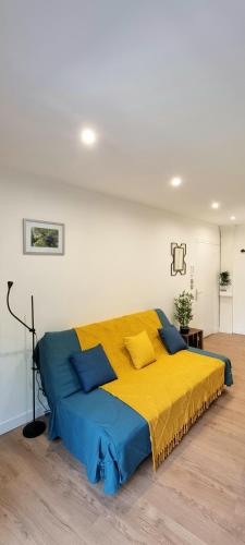 - un grand lit avec une couverture jaune et bleue dans l'établissement STUDIO SIMONE - TERRASSE ET JARDIN - TV - WIFI, à Toulouse