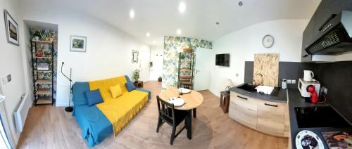 un salon avec un canapé jaune et une table dans l'établissement STUDIO SIMONE - TERRASSE ET JARDIN - TV - WIFI, à Toulouse