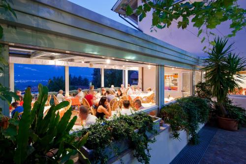 a group of people sitting at tables on a patio at Hotel Residence Pernhof in Termeno