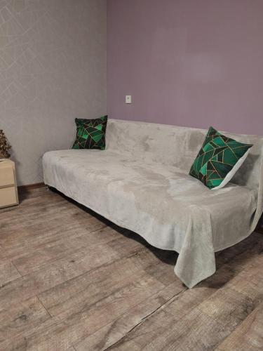 a couch with two pillows on it in a room at Apartment Sports Palace Просторная квартира рядом Дворец Спорта in Kharkiv