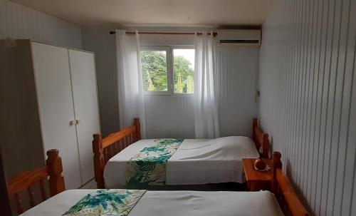 Cette petite chambre comprend 2 lits et une fenêtre. dans l'établissement Gîtes Plais'Anse, à Trois-Rivières