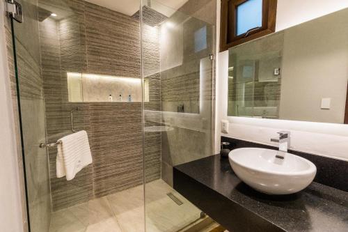 a bathroom with a sink and a glass shower at Casa Naila Hotel Boutique in Oaxaca City