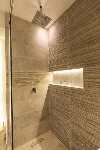 a bathroom with a shower with a glass door at Casa Naila Hotel Boutique in Oaxaca City