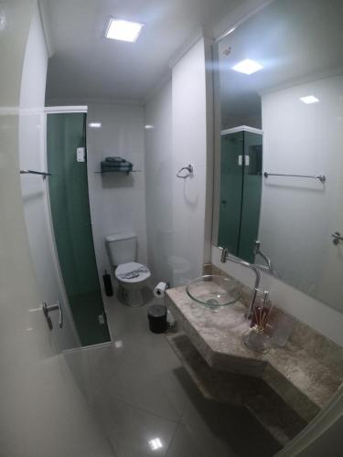 y baño con lavabo, ducha y aseo. en Apartamento Refúgio das Thermas, en Piratuba