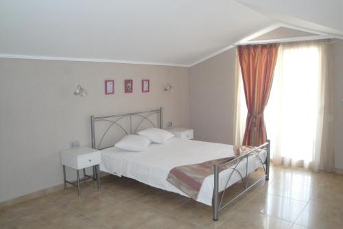 een slaapkamer met een bed met witte lakens en kussens bij Amaryllis Studios in Asprovalta