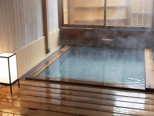 an indoor swimming pool with smoke coming out of it at Shojuen in Minakami