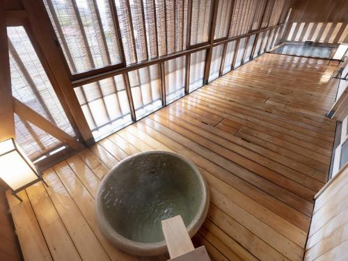 a large bath tub sitting on a wooden floor at Shojuen in Minakami