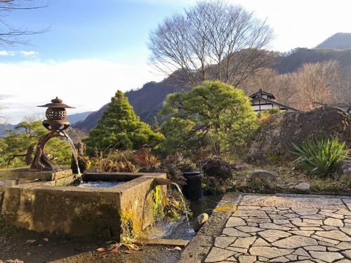 a water fountain in the middle of a garden at Shojuen in Minakami