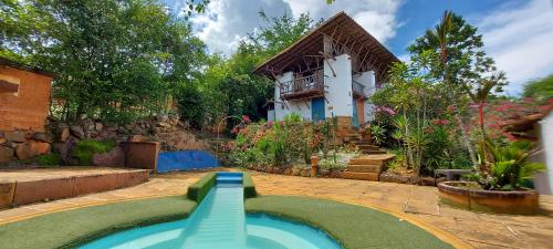 a swimming pool in a yard with a house at Hotel El Cogollo By MH in Barichara