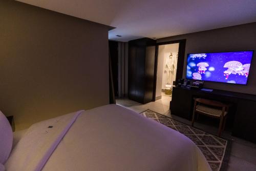 a bedroom with a bed and a flat screen tv at Casa Naila Hotel Boutique in Oaxaca City