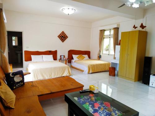 um quarto com duas camas e uma mesa em Ez Bay Homestay em Chenggong