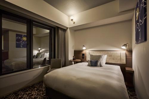 a hotel room with a large bed and a mirror at The Royal Park Canvas - Kyoto Nijo in Kyoto