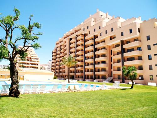 a resort with a swimming pool and a large building at Apartamentos Paraíso Sol da Rocha in Portimão