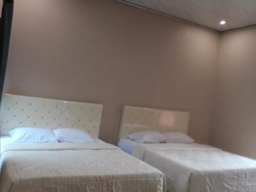 a bedroom with two beds with white sheets at VILLA PRINGGITAN in Karanganyar