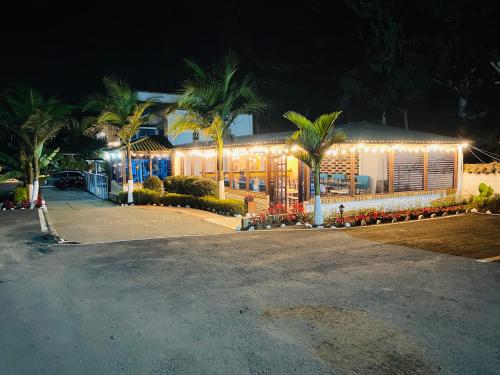 a house lit up at night with lights on it at Hotel Las Palmeras Gachancipa in Gachancipá