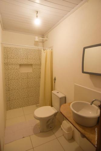 a bathroom with a toilet and a sink at Suíte Central in Lençóis