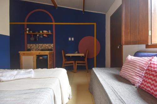 a bedroom with a bed and a table with a chair at Suíte Central in Lençóis