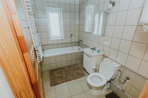 La salle de bains est pourvue de toilettes, d'une baignoire et d'un lavabo. dans l'établissement Zielone Zagrody - Cieplice, à Adamówka