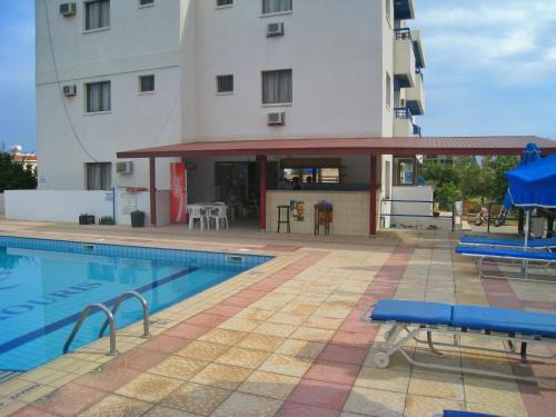 a swimming pool in front of a building at Maouris Hotel Apartments in Protaras