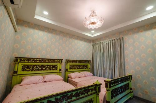 a bedroom with two beds and a chandelier at Iris Homestay in Ban Muang