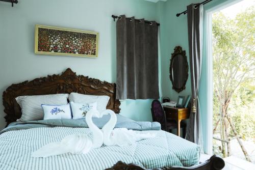 two swans are sitting on a bed in a bedroom at Iris Homestay in Ban Muang