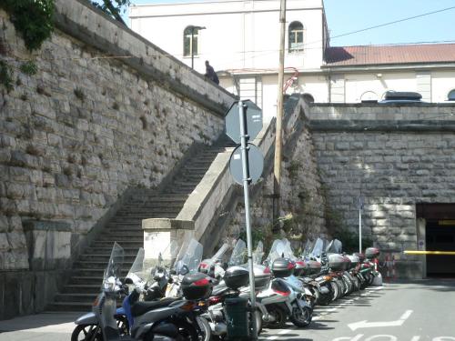 een rij motorfietsen geparkeerd naast een bakstenen muur bij Hotel Aurora in La Spezia