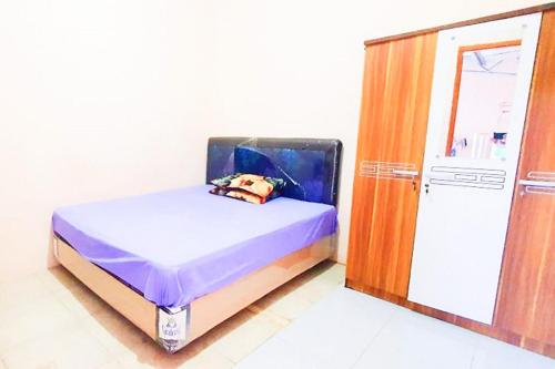 A bed or beds in a room at Green Kanca Syariah Guest House Mitra RedDoorz