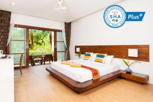a hotel room with a bed and a sign that says sla plus at Montalay Beach Resort - SHA Plus in Ko Tao