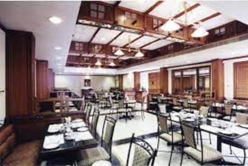 a restaurant with tables and chairs in a room at Hotel Kalyan Residency in Tirupati
