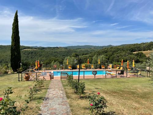 uma piscina num campo relvado com uma árvore em Farmhouse Gello by ToscanaTour em Montecatini Val di Cecina