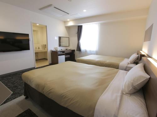 Tempat tidur dalam kamar di Hotel New Gaea Nishi Kumamoto Ekimae