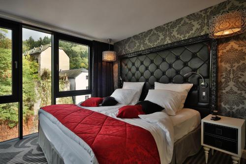 a bedroom with two beds and a large window at Le Clervaux Boutique Hotel & Spa in Clervaux