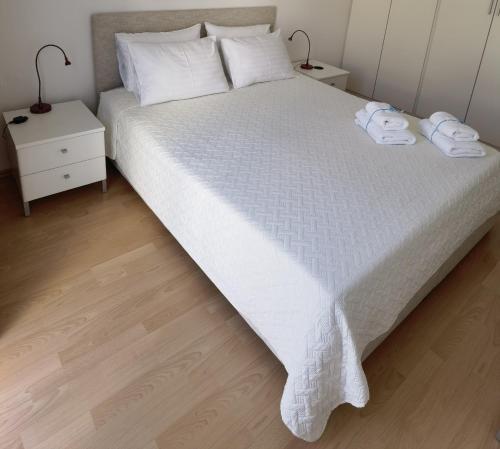 una camera da letto con un letto bianco con due asciugamani sopra di ARIA apartment with beautiful terrace with sea & park view a Novigrad Istria