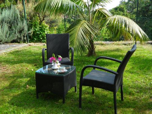 two chairs and a table in the grass at Hotel Villa Degli Aranci in Maratea
