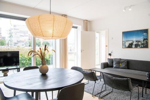 a living room with a table and a couch at The Beach Gardens by Daniel&Jacob's in Copenhagen