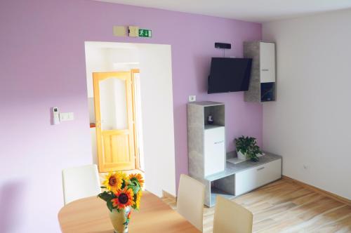 a living room with a vase of flowers on a table at APARTMA KMETIJA ROVAN in Vrhpolje