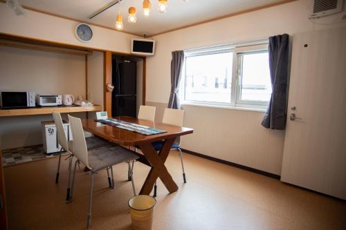 um quarto com uma mesa e cadeiras de madeira e uma janela em Otaru Village - Vacation STAY 84438 em Otaru